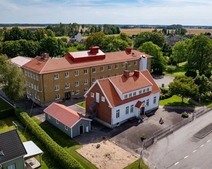 En flygbild av en skolbyggnad med ett rött tak.